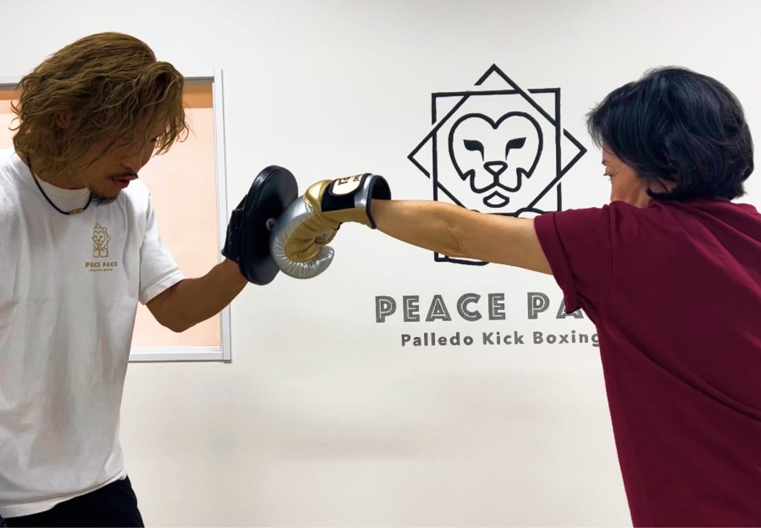 男性トレーナーとパンチする女性